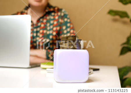 a worker stacking coins on a white podium in an office setting, representing financial success and achievement, suitable for finance-related presentations, business seminars, or investment workshops a worker stacking coins on a white podium in an office setting, representing financial success and achievement, suitable for finance-related presentations, business seminars, or investment workshops 113143225