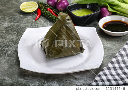 Asian cuisine - rice with filling in banana leaf 113143346