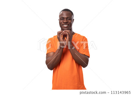 young modest handsome african man with short haircut wearing orange t-shirt waiting for good luck 113143965