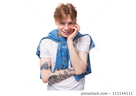 portrait of a young pensive european man with red hair and a tattoo on his arms on a studio 113144111