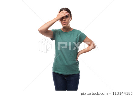 young slender european woman with a ponytail hairstyle is dressed in a green t-shirt thoughtful 113144195