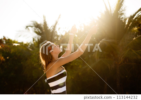 Spa wellness beach beauty woman relaxing and sun bathing on beach. Beautiful serene and peaceful young female model on holiday travel resort enjoting vacation. Sun protection concept 113144232
