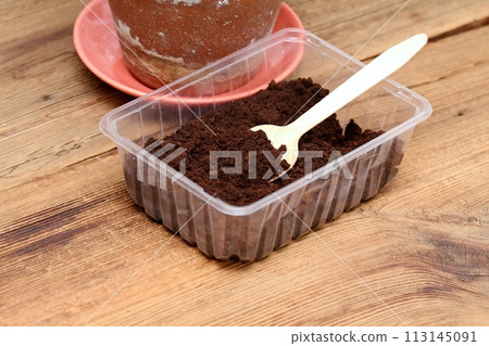 Coffee grounds in a box with spoon as natural organic fertilizer. Coffee grounds in a box with spoon as natural organic fertilizer. 113145091