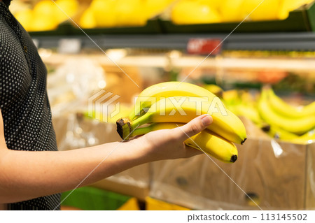Boy holding a bunch of bananas in the supermarket Boy holding a bunch of bananas in the supermarket 113145502
