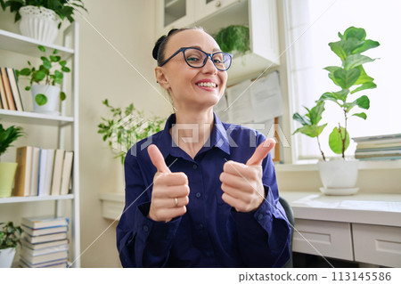 Webcam view of smiling woman showing thumbs up ok sign 113145586