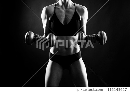 Woman training with dumbbells, pumping up muscles of hands and legs. 113145627