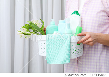 A basket with detergents in the hands of a woman A basket with detergents in the hands of a woman 113145886