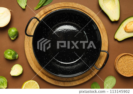 A pan for cooking on the table, with ingredients. 113145902
