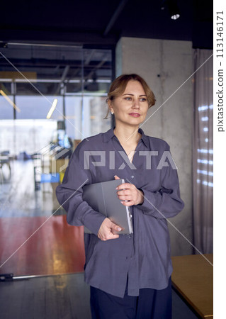 a beautiful business woman enters the conference room with a laptop in her hands 113146171