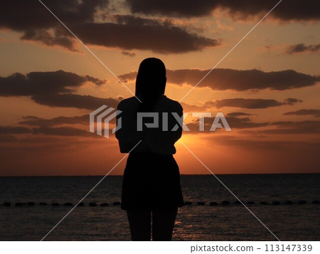 Girl watching the sunset 113147339