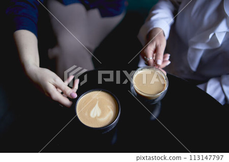 old mother and middle-aged daughter drinking coffee and talking in the cafe old mother and middle-aged daughter drinking coffee and talking in the cafe 113147797