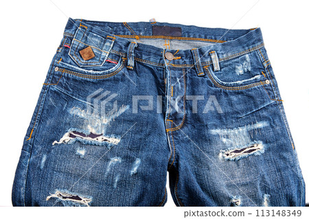 A fragment of blue denim trousers with scuffs on the elements on a white background 113148349