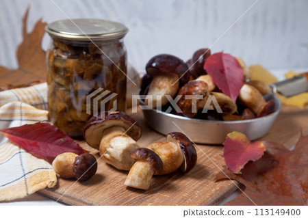 Several Imleria Badia or Boletus badius mushrooms commonly known as the bay bolete and vintage pan with mushrooms on wooden cutting board.. Several Imleria Badia or Boletus badius mushrooms commonly known as the bay bolete and vintage pan with mushrooms on wooden cutting board.. 113149400