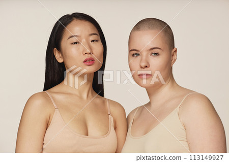 Medium closeup studio portrait of diverse young Asian and Caucasian women wearing neutral toned underwear posing for camera Medium closeup studio portrait of diverse young Asian and Caucasian women wearing neutral toned underwear posing for camera 113149927