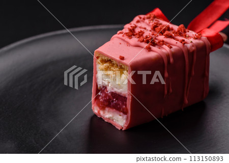 Delicious sweet cheesecake with fruits covered with icing with a wooden stick Delicious sweet cheesecake with fruits covered with icing with a wooden stick 113150893