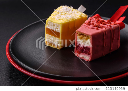 Delicious sweet cheesecake with fruits covered with icing with a wooden stick 113150939