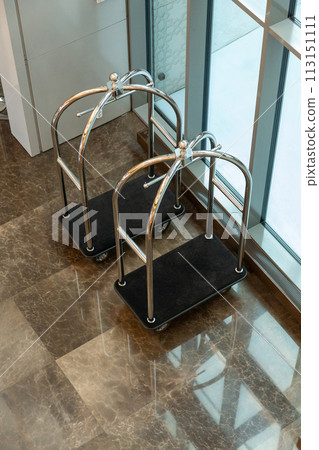 Vacant brass luggage carts at the entrance of a luxury city hotel. Vacant brass luggage carts at the entrance of a luxury city hotel. 113151111