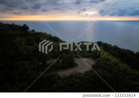 Curvy road winds towards Black sea, with sunset reflecting on water, georgia 113151614