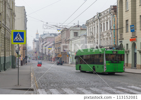 [Ukraine] Green public buses and historic streets running on cobblestone roads in Kharkiv city 113152081