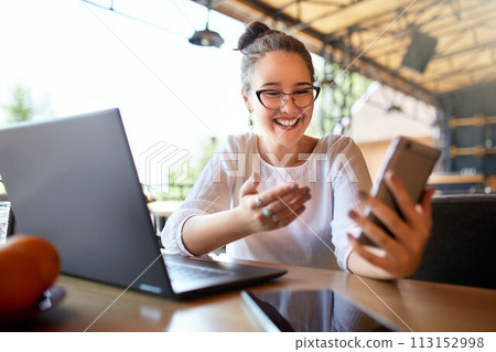 Surprised freelancer mixed race woman looks at smartphone and can not believe she won lottery prize. Successfull amazed asian caucasian businesswoman communicating in video call conference chat. Surprised freelancer mixed race woman looks at smartphone and can not believe she won lottery prize. Successfull amazed asian caucasian businesswoman communicating in video call conference chat. 113152998