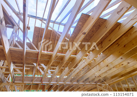 During construction of new unfinished residential home, wood framing supports beam During construction of new unfinished residential home, wood framing supports beam 113154071