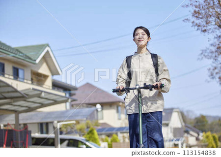 A Japanese woman riding an electric scooter through a residential area A Japanese woman riding an electric scooter through a residential area 113154838