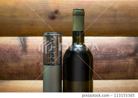 An electric corkscrew, a bottle of wine and a bottle opener lie on a dark wood background An electric corkscrew, a bottle of wine and a bottle opener lie on a dark wood background 113155385