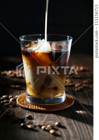 cold milk poured into iced coffee cold milk poured into iced coffee 113156713