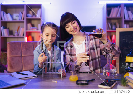 Young woman and small girl improving knowledge enjoying studying. Young woman and small girl improving knowledge enjoying studying. 113157690