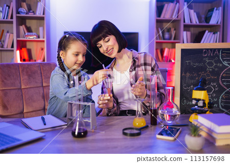Caucasian mother making chemical experiments or tests with smart cute daughter. Caucasian mother making chemical experiments or tests with smart cute daughter. 113157698