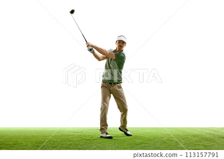 Professional golfer in casual attire in mid-swing with driver on artificial turf against white studio background. 113157791