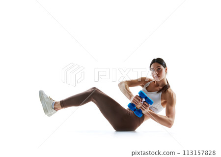 Young woman doing seated dumbbells, weights russian twist in motion against white studio background. Young woman doing seated dumbbells, weights russian twist in motion against white studio background. 113157828