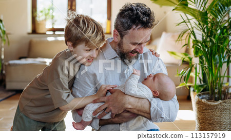 Father and boy holding newborn baby. New sibling. Unconditional paternal love, Father's Day concept. 113157919