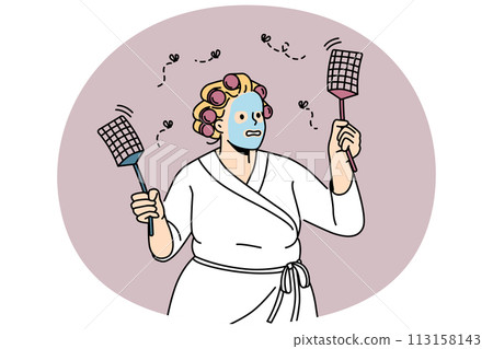Funny woman in bathrobe chasing flies with swatters 113158143