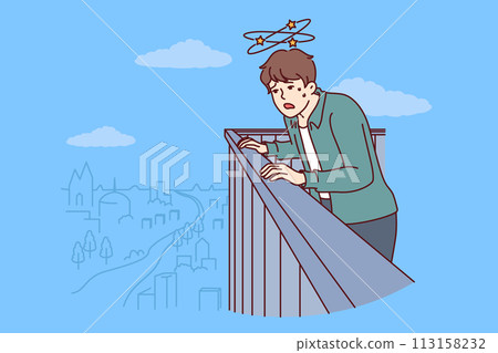 Frightened man with acrophobia and fear of heights looks down from roof of skyscraper 113158232