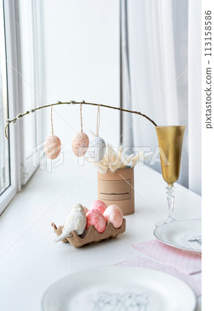 Table set with dishware, stemware, and Easter decorations Table set with dishware, stemware, and Easter decorations 113158586