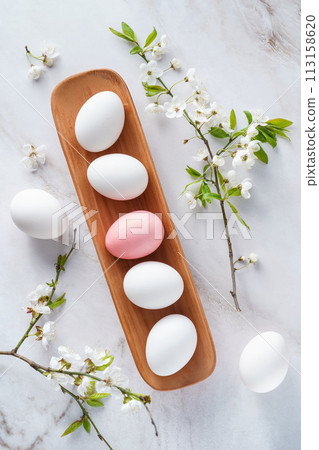 Wooden tray with white and pink eggs, flowers comfort food ingredients Wooden tray with white and pink eggs, flowers comfort food ingredients 113158620