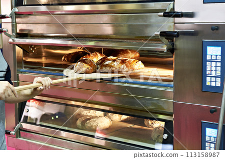 Man is baking bread in oven Man is baking bread in oven 113158987