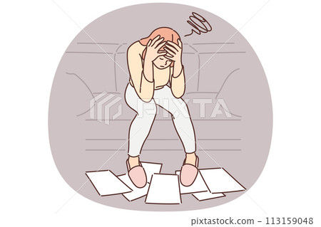 Woman frustrated with financial problems, sits with head bowed over papers scattered on floor 113159048
