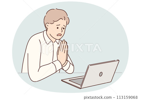 Man manager prays sitting at table with laptop asking god for help after making mistakes in project 113159068