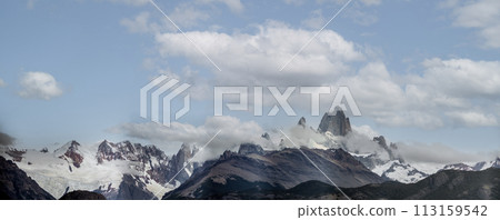 Majestic Mountain Peaks Covered by Snow and Clouds 113159542