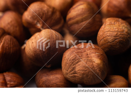 Close-up of Hulled whole cobalt or hazelnut seeds of Corylus avellana. Macro photo of food, close up from above Close-up of Hulled whole cobalt or hazelnut seeds of Corylus avellana. Macro photo of food, close up from above 113159743