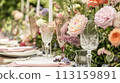 Table setting with rose flowers and candles for an event party or wedding reception in summer garden. 113159891