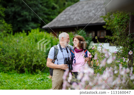 Active elderly couple on trip together, during spring day. Senior tourists visiting, exploring new places. Sightseeing, holding hands. 113160047
