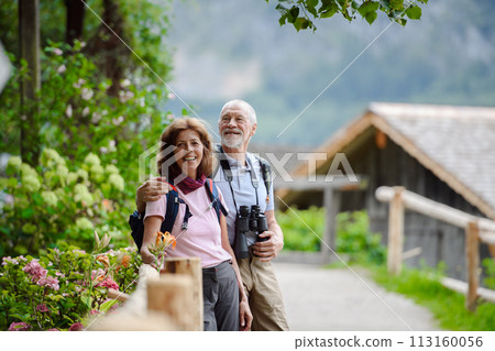 Active elderly couple on trip together, during spring day. Senior tourists visiting, exploring new places. Sightseeing, holding hands. Active elderly couple on trip together, during spring day. Senior tourists visiting, exploring new places. Sightseeing, holding hands. 113160056