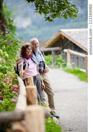 Active elderly couple on trip together, during spring day. Senior tourists visiting, exploring new places. Sightseeing, holding hands. 113160060