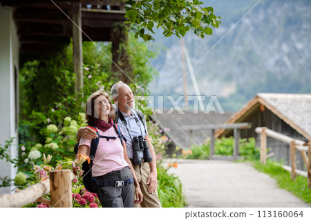 Active elderly couple on trip together, during spring day. Senior tourists visiting, exploring new places. Sightseeing, holding hands. Active elderly couple on trip together, during spring day. Senior tourists visiting, exploring new places. Sightseeing, holding hands. 113160064
