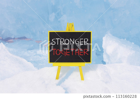 Stronger together symbol. Concept words Stronger together on beautiful yellow black blackboard. Beautiful blue ice background. Business, motivational and stronger together concept. 113160228