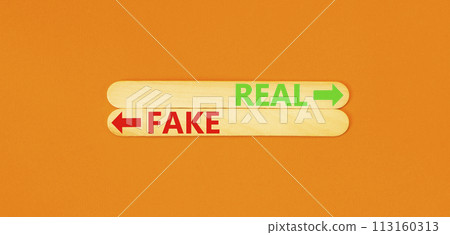 Real or fake symbol. Concept word Real or Fake on beautiful wooden stick. Beautiful orange table orange background. Business and real or fake concept. Copy space. Real or fake symbol. Concept word Real or Fake on beautiful wooden stick. Beautiful orange table orange background. Business and real or fake concept. Copy space. 113160313