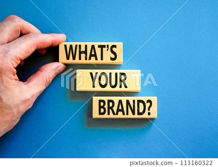 Branding and what is your brand symbol. Concept words What is your brand on beautiful blocks. Beautiful blue background. Businessman hand. Business branding what is your brand concept. Copy space. 113160322